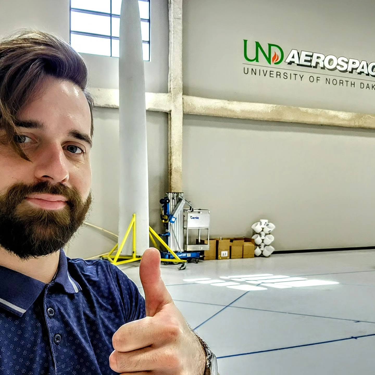 Jeremy Pagel giving a thumbs up at UND Aerospace