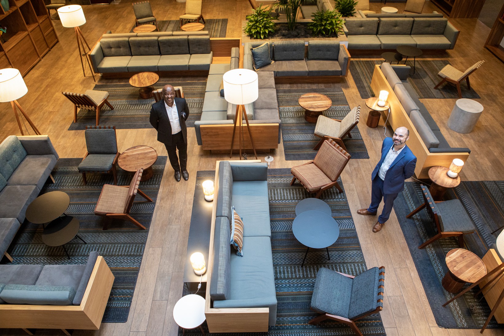 Hotel revenue executive surrounded by forecast reports, pipeline charts, and CRM dashboards in a luxury hotel lobby