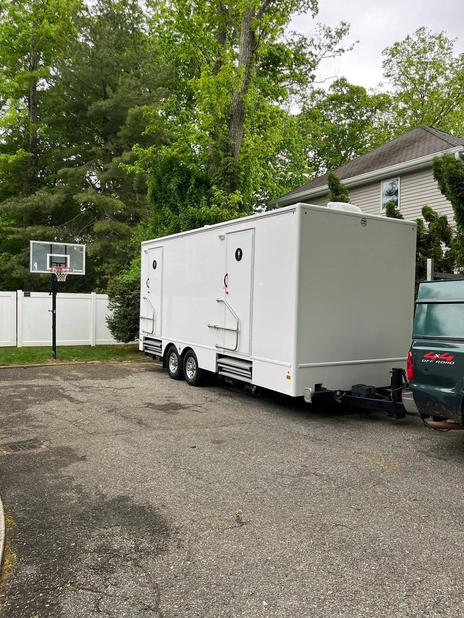 White luxury multi-stall restroom trailer staged on a residential driveway on Long Island