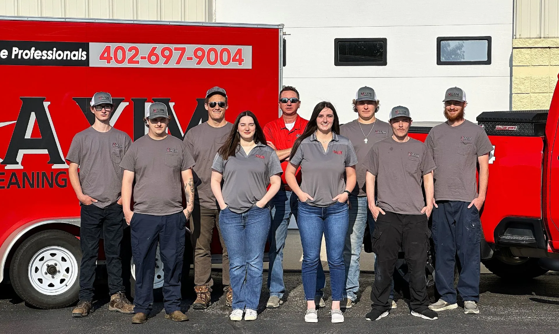 The Maxim Cleaning & Restoration team standing together in front of company vehicles