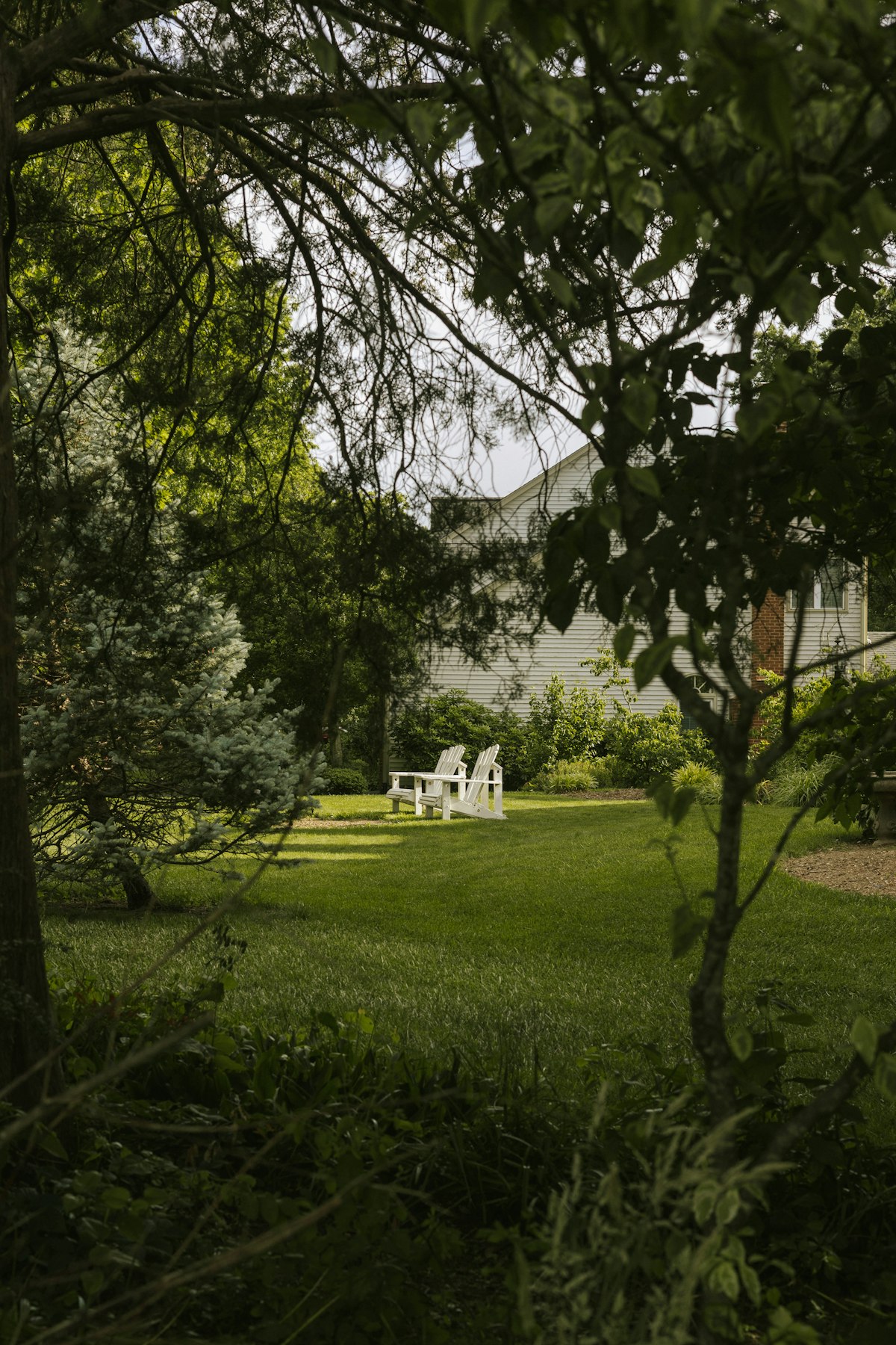 Backyard seating area with white chairs on green turf in Arlington TX