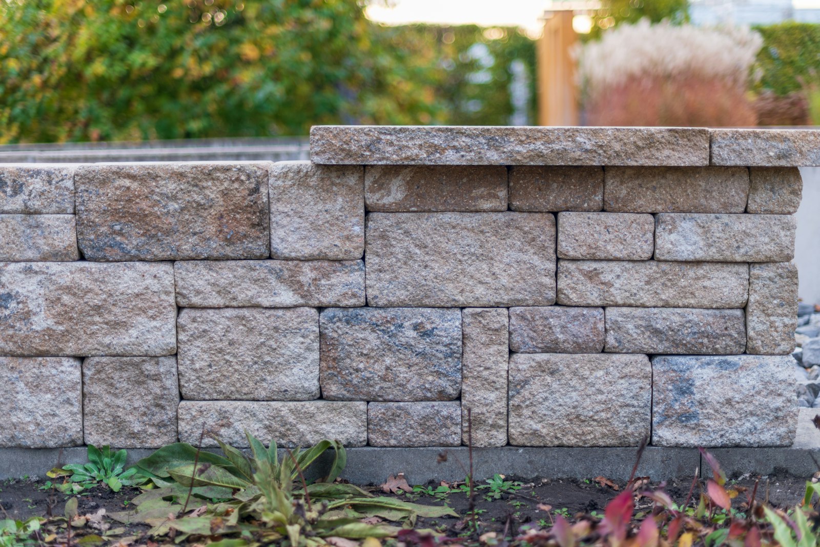 Stone retaining wall with plantings along a residential yard in Arlington TX