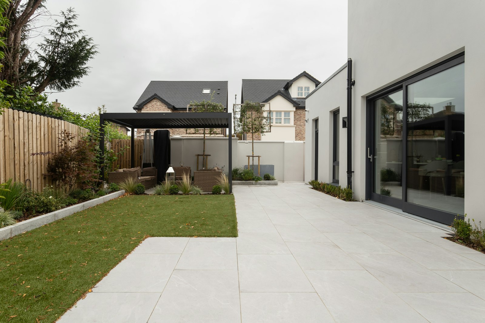 Backyard pergola and covered patio over a paved area in Arlington TX