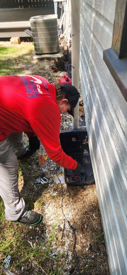 Absolute Termite & Pest Control technician inspecting a bait station on-site in Central Alabama
