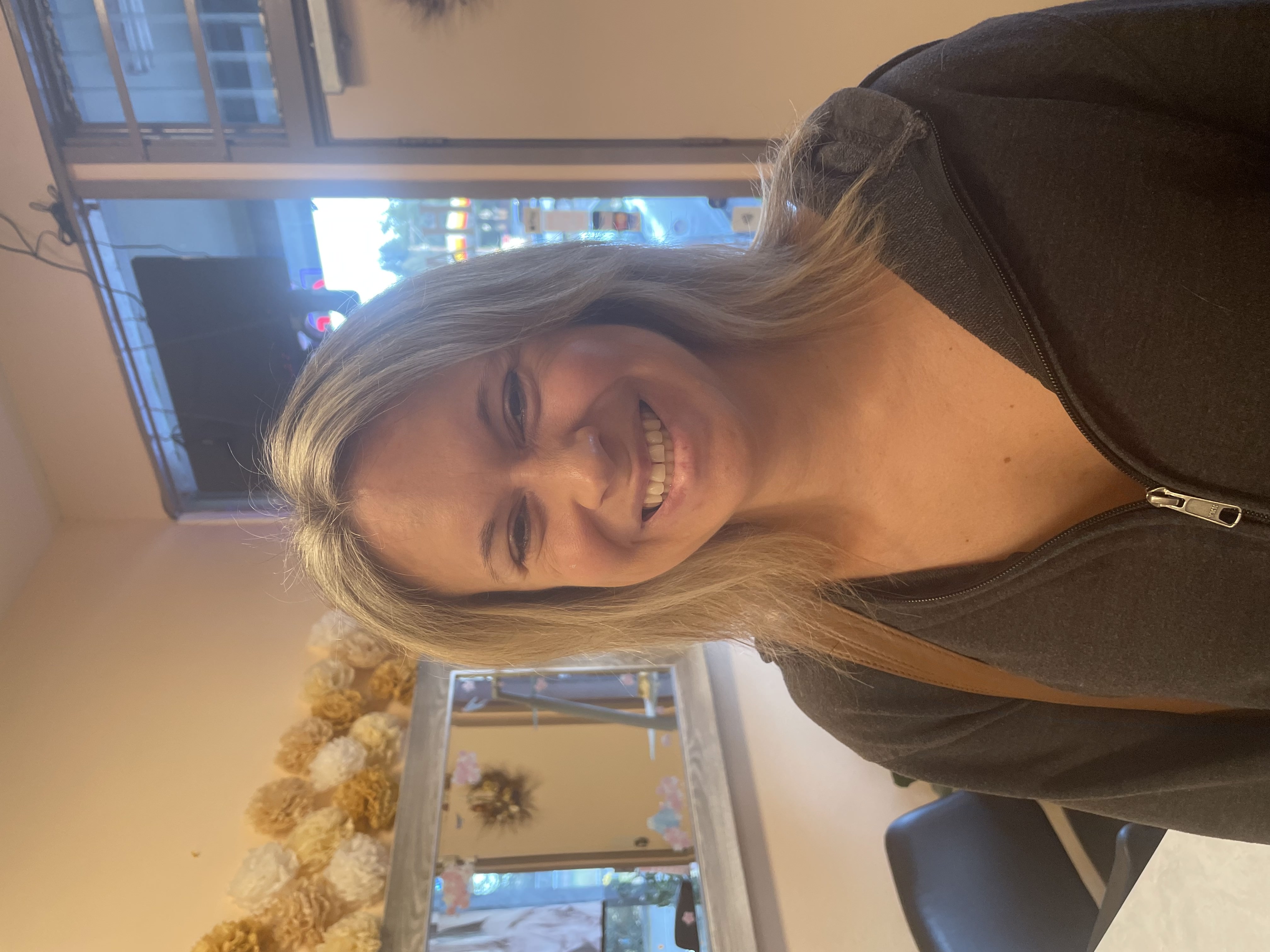 Client with dimensional blonde highlights and a layered haircut at Ideal Hair Salon in Edmonds.