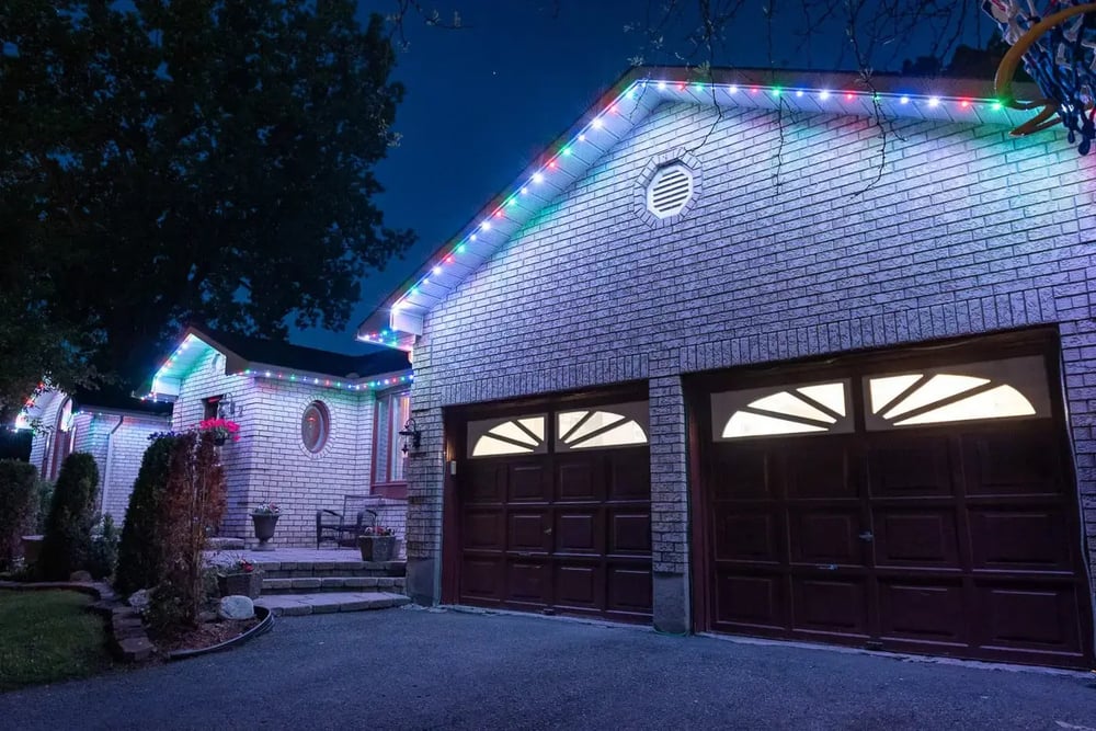 Elegant permanent roofline and eave lighting glowing at dusk