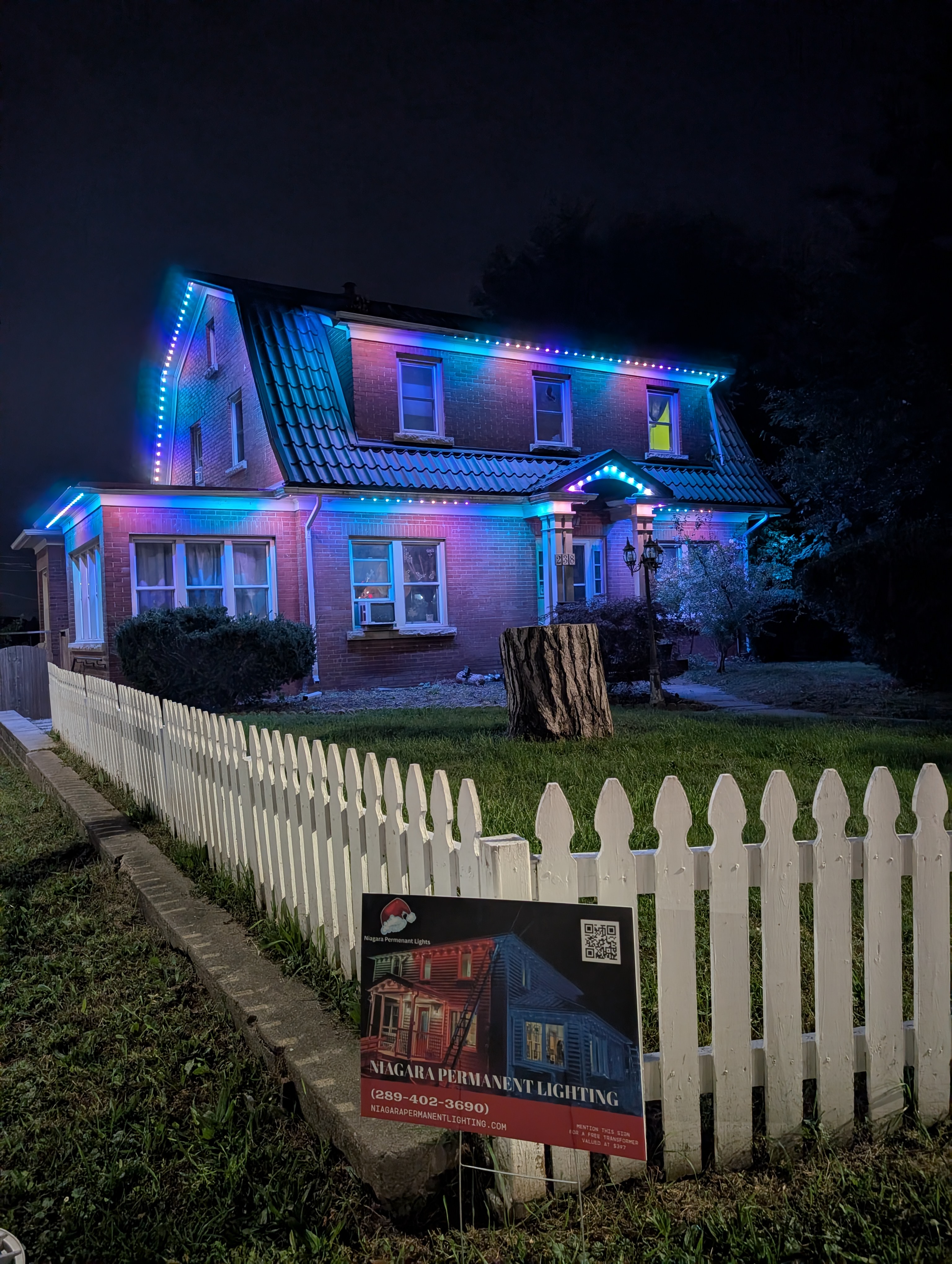 The home at night with permanent Birthday LED outdoor lighting glowing along the roofline