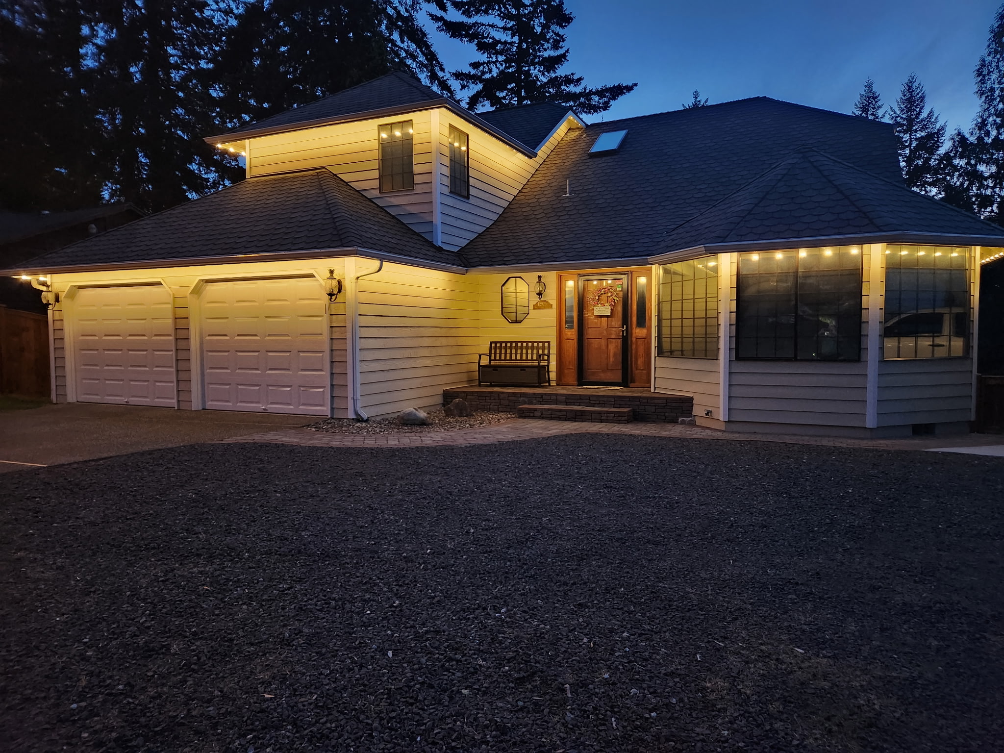 Home with elegant warm roofline lighting at dusk
