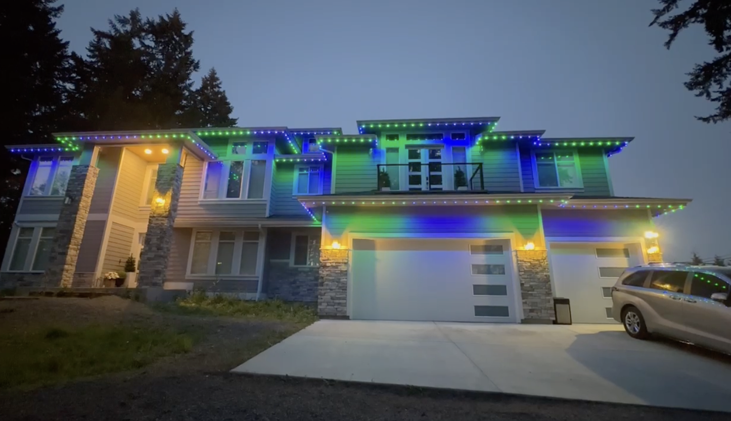Home with colorful permanent roofline lighting