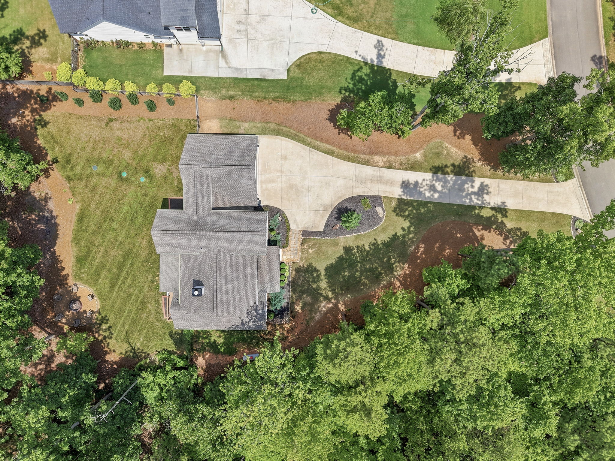 Top-down drone photograph showing property roof, driveway, and landscaping details from directly above