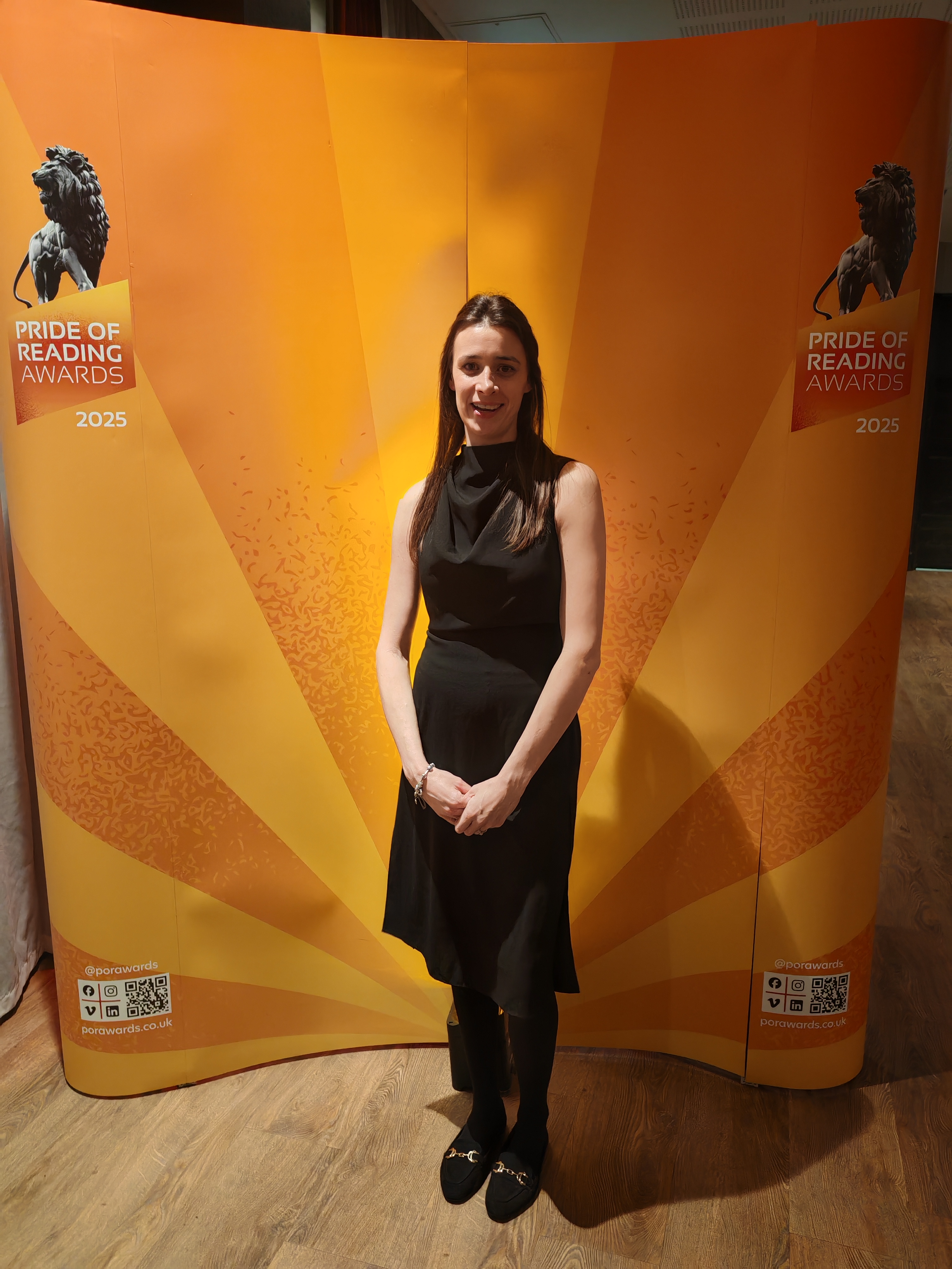 Team member at Pride of Reading Awards 2025 ceremony backdrop
