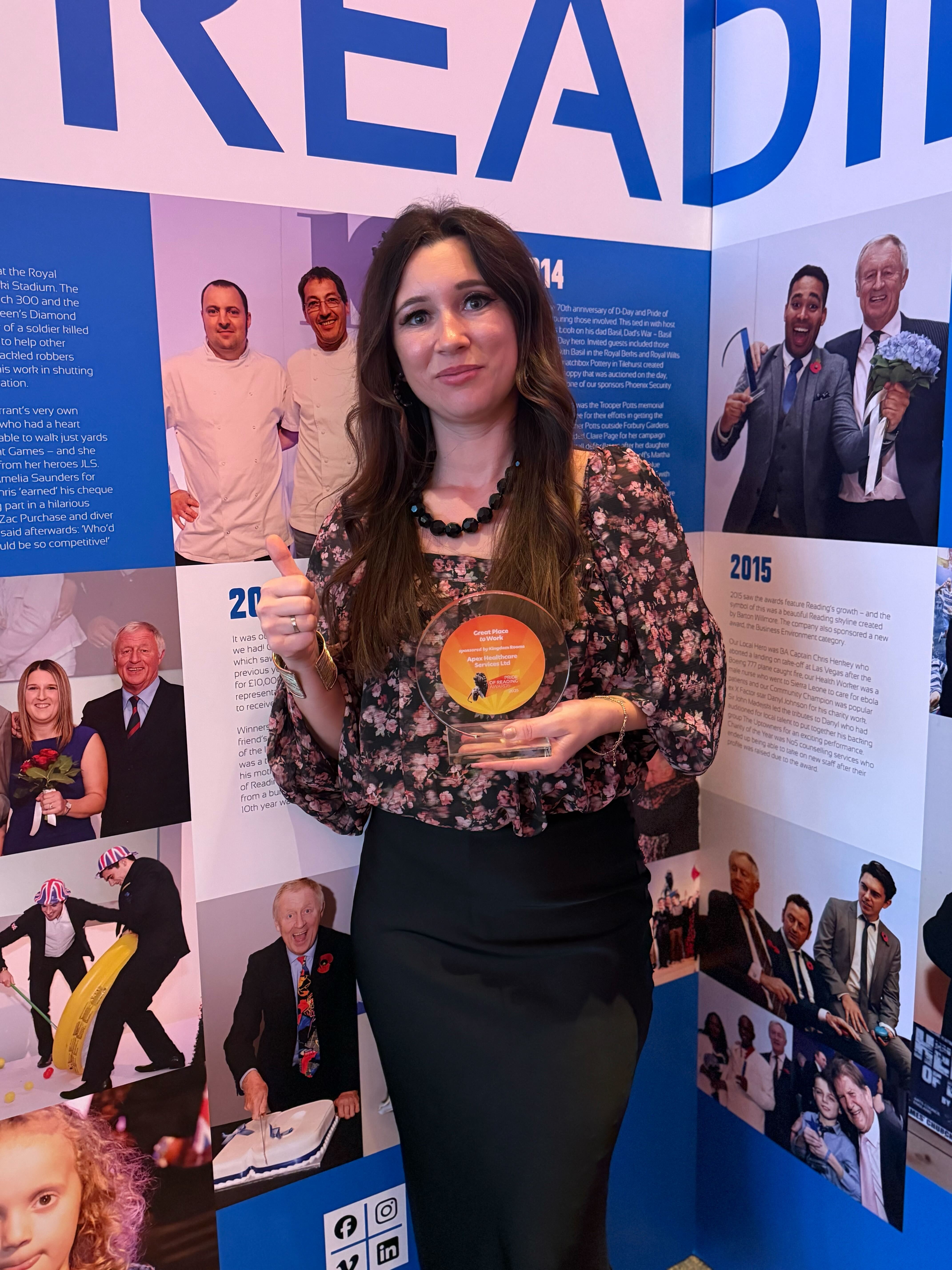 Apex team member holding the Pride of Reading Great Place to Work trophy at the ceremony