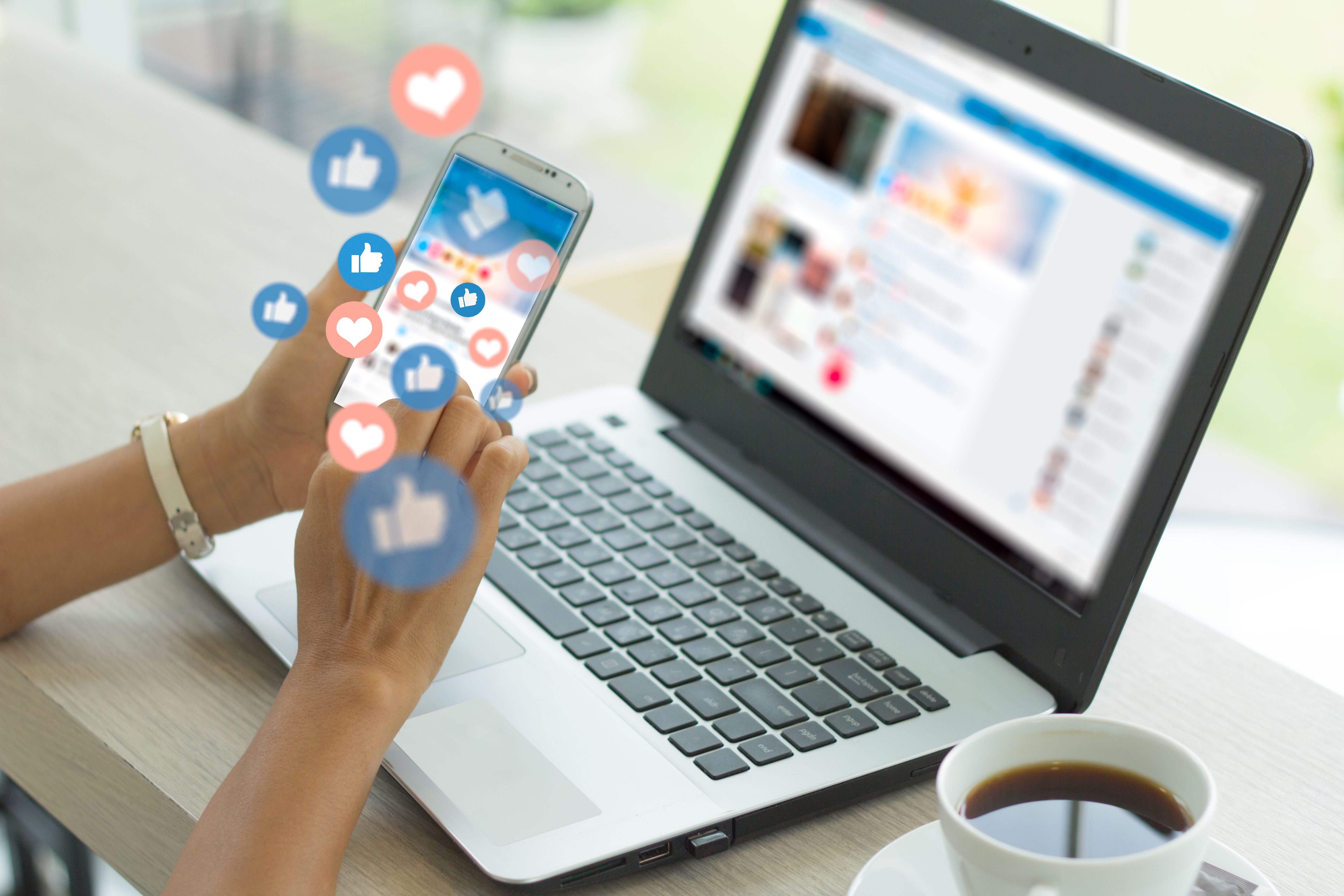 Social media management with phone and laptop showing engagement