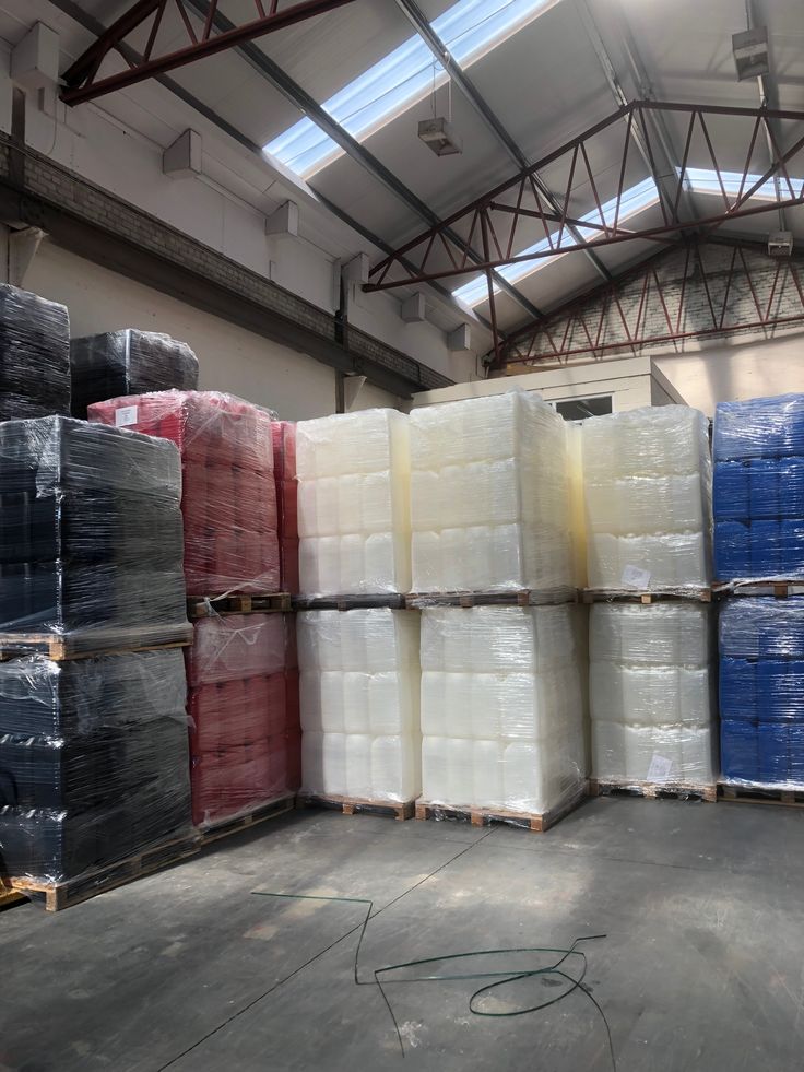Warehouse storage area with plastic bales wrapped in black, red, white, and blue