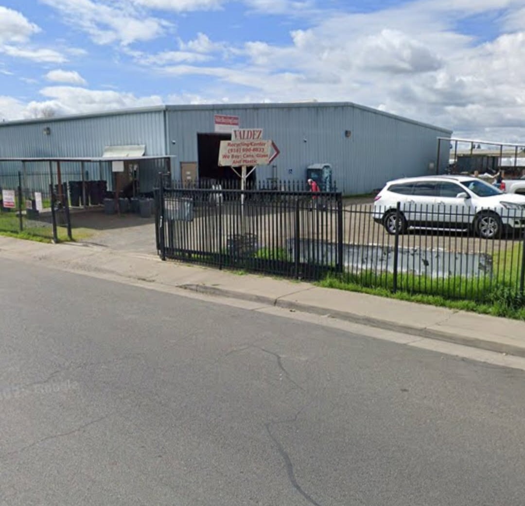 Valdez Recycling facility exterior with sign, metal building, and gated entrance on Kent Street