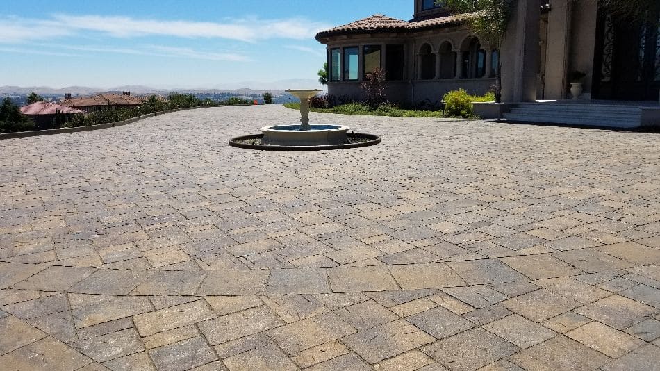 Expansive multi-tone paver courtyard with central fountain at Mediterranean estate - Paradise Building Materials project