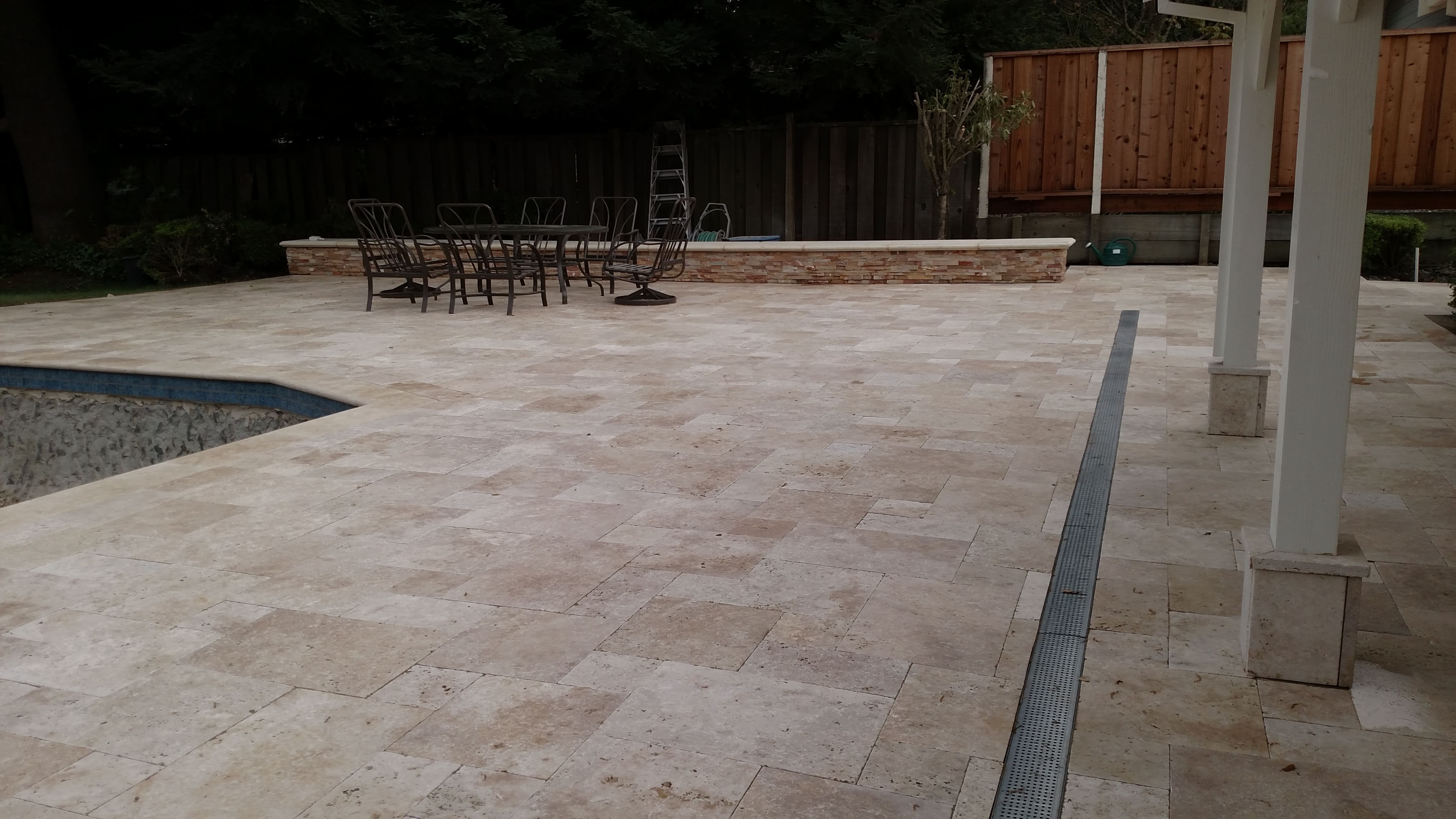 Travertine stone patio and pool deck with outdoor dining area - natural stone supplied by Paradise Building Materials