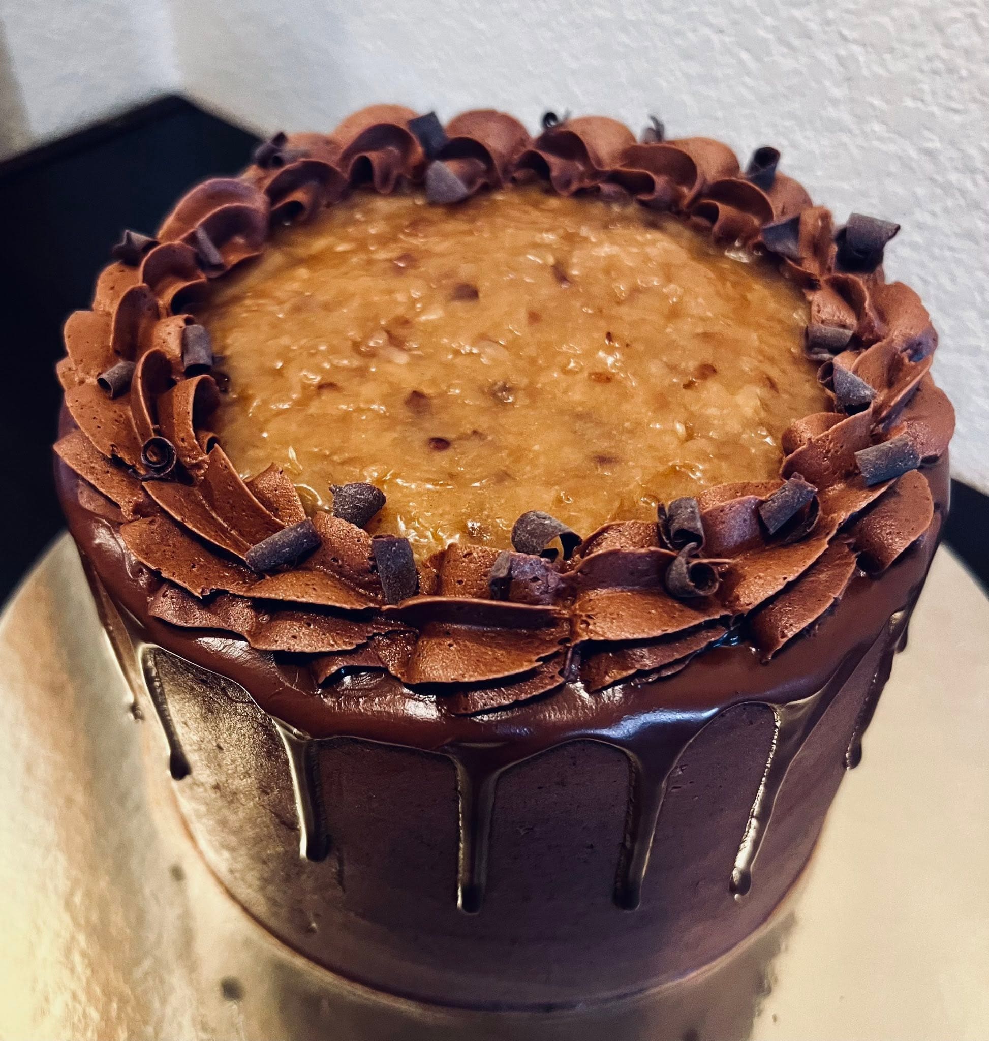 Rich chocolate cake with caramel filling piped chocolate border and chocolate curls from Sweet Tooth Creations Anchorage