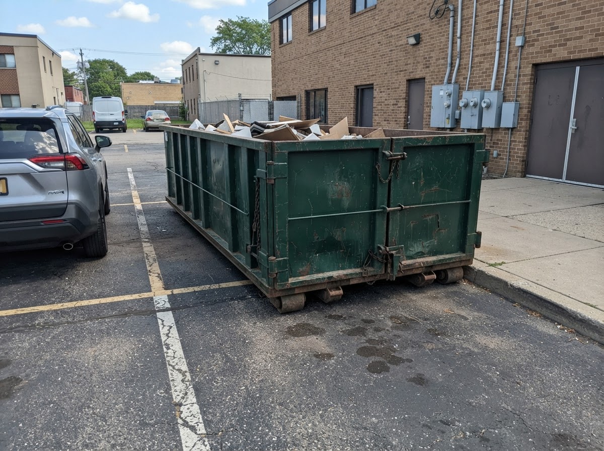 30-yard roll-off container tucked against a loading bay at dusk