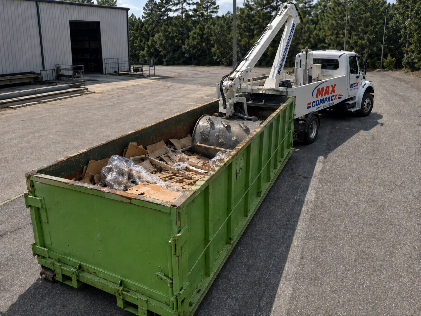 Compaction drum working inside a roll-off container full of packaging and pallets
