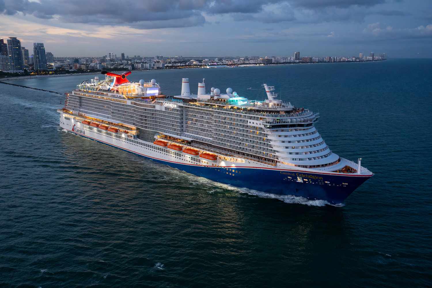 Carnival Celebration cruise ship sailing along the Florida coastline during evening twilight