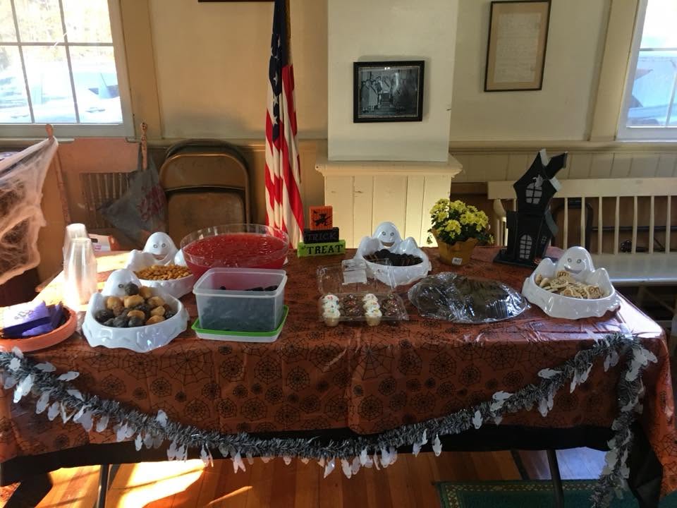 Community Halloween celebration inside the Grange hall with treats and festive decorations
