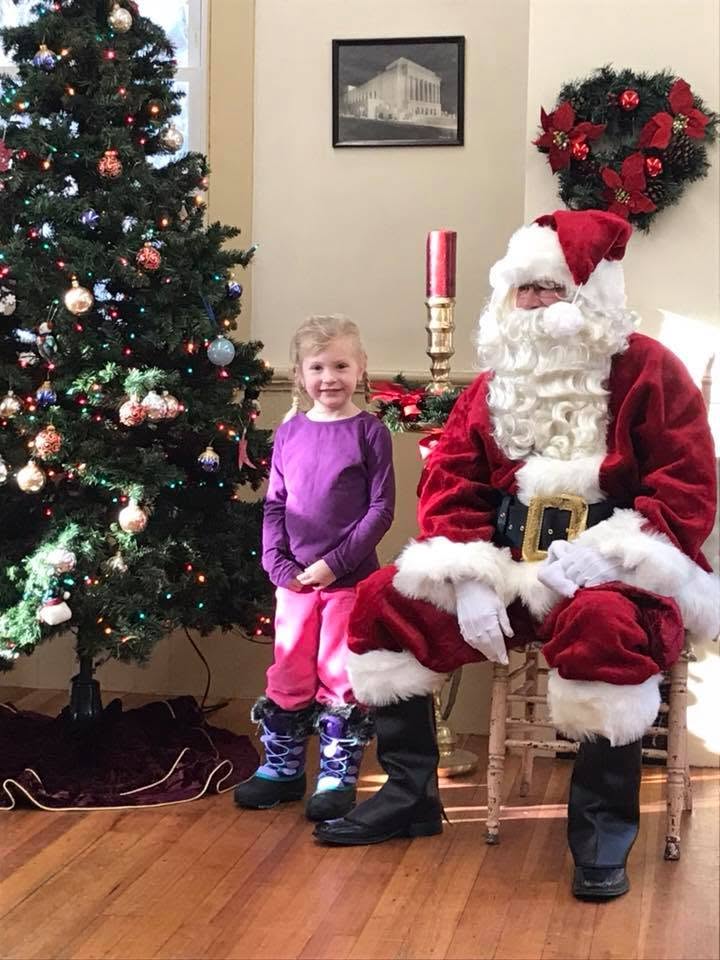 Santa visiting with a child during the annual Christmas gathering at the Grange