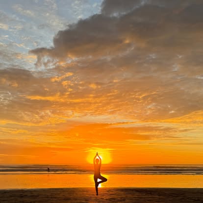 Golden hour beach yoga tree pose in Nosara