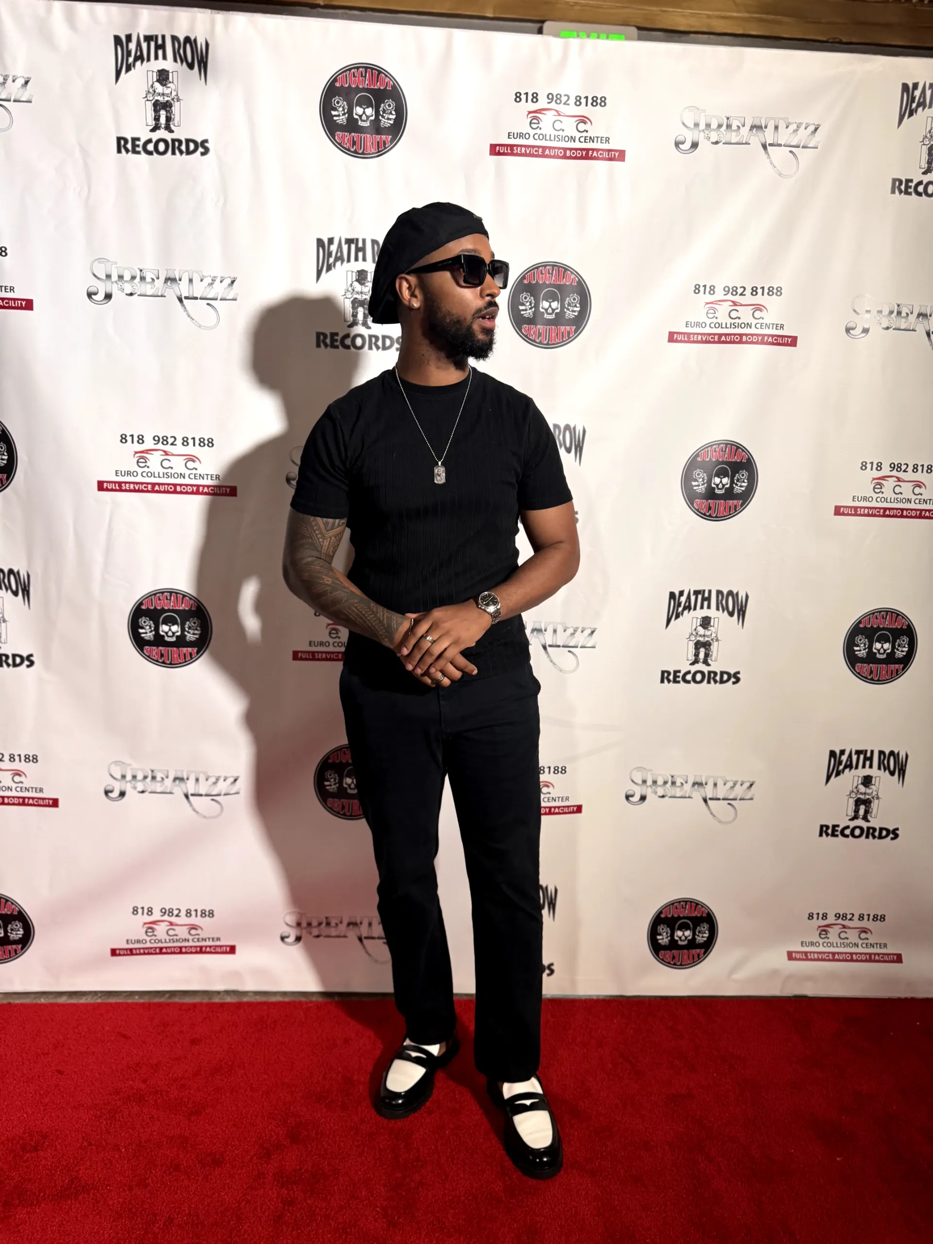 Jai'koa Parham on the red carpet in a black beret, sunglasses, and two-tone loafers, event appearance