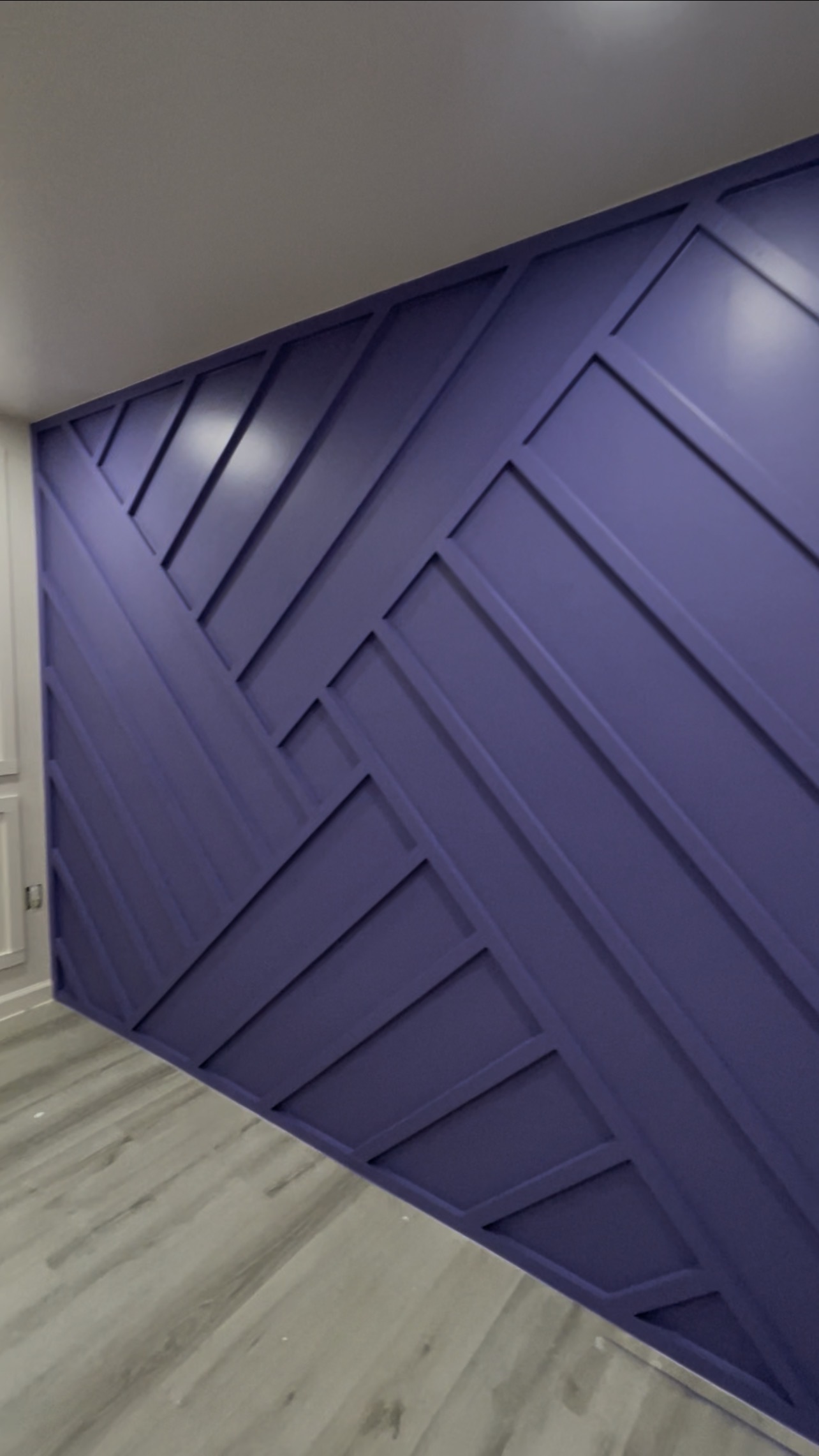 Professional painter applying smooth purple accent wall finish in a Houston home