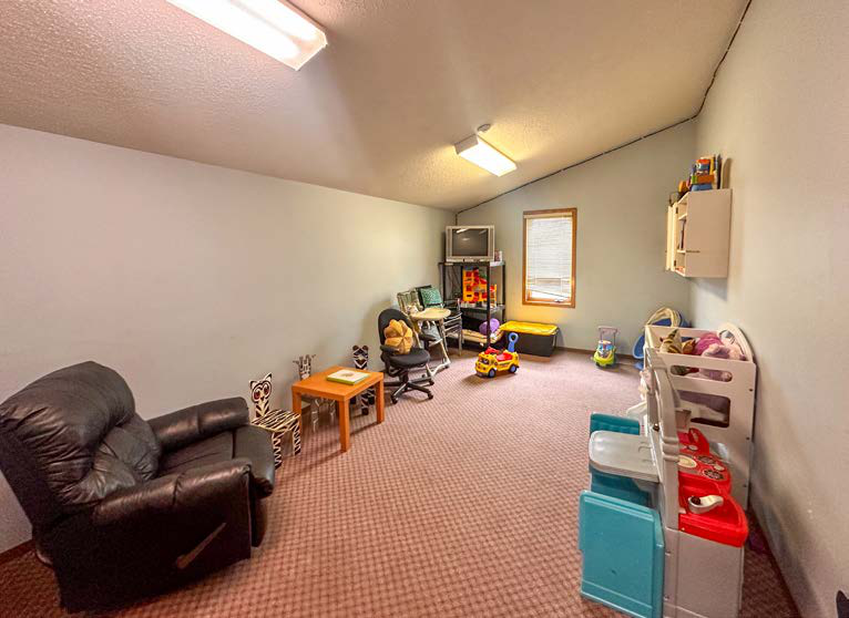 Children's room with toys and seating area inside the property