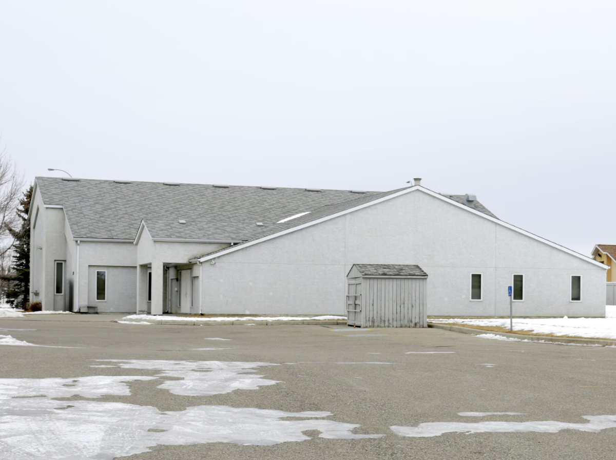 Rear view of the property with parking area and surrounding land