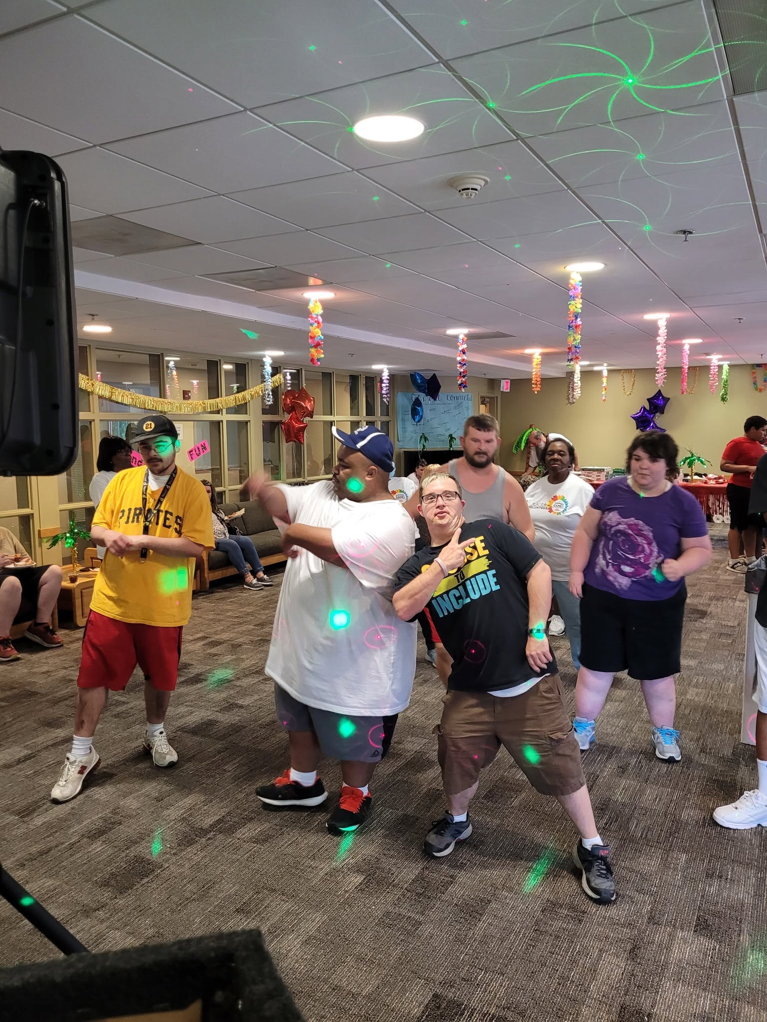 Guests dancing under colorful laser lights at a Delaware party celebration