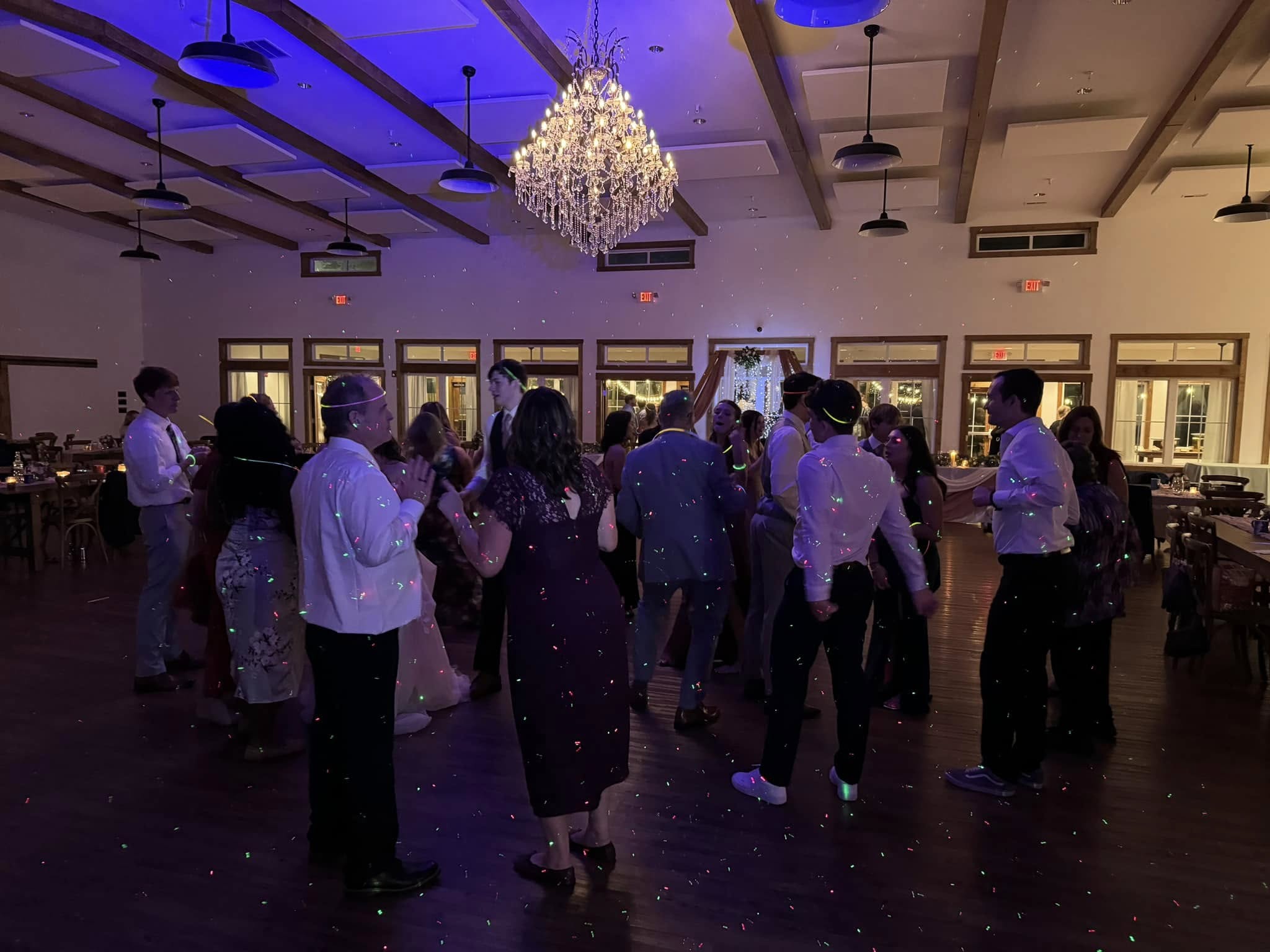 Crowded dance floor with laser lights and chandelier lighting at a Delaware event