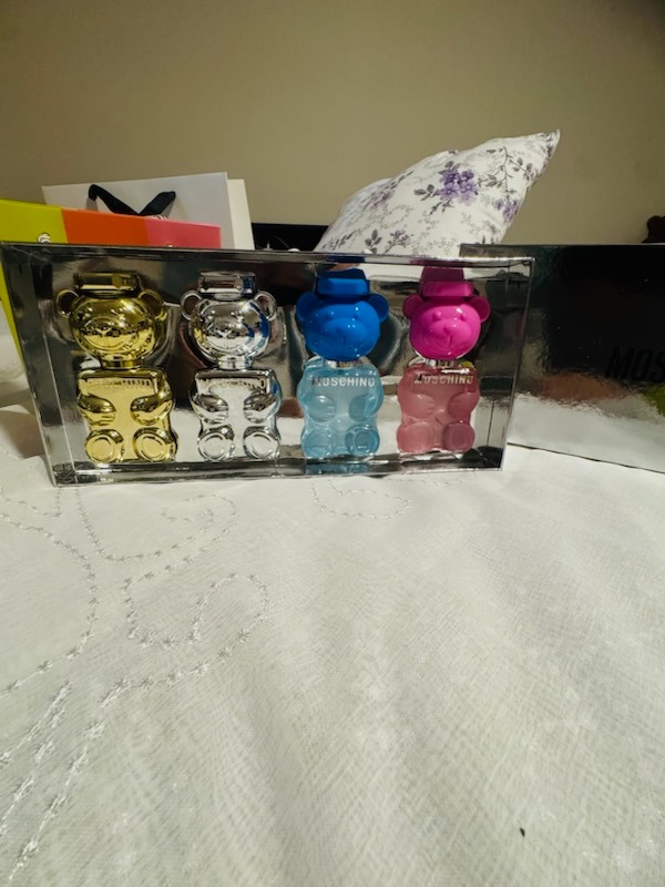 Moschino Toy bear perfume miniature collection set featuring four bear-shaped fragrance bottles in metallic gold, silver, translucent blue, and pink