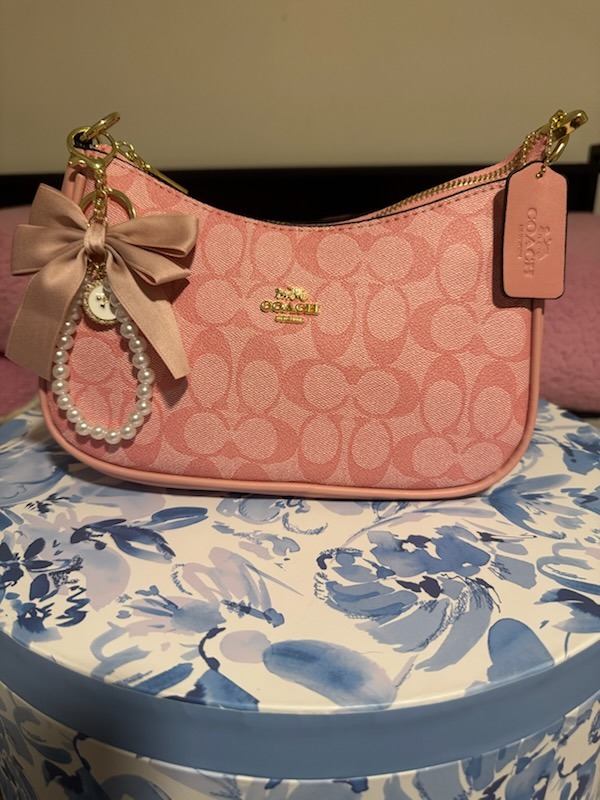Pink blush Coach signature monogram shoulder bag with pink satin bow charm pearl beaded keychain gold zipper hardware COACH tag on elegant floral display box