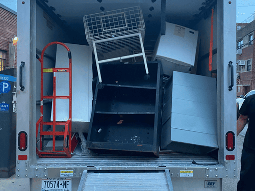 TopDog Junk Removal crew loading truck with furniture and appliances in Staten Island, NY