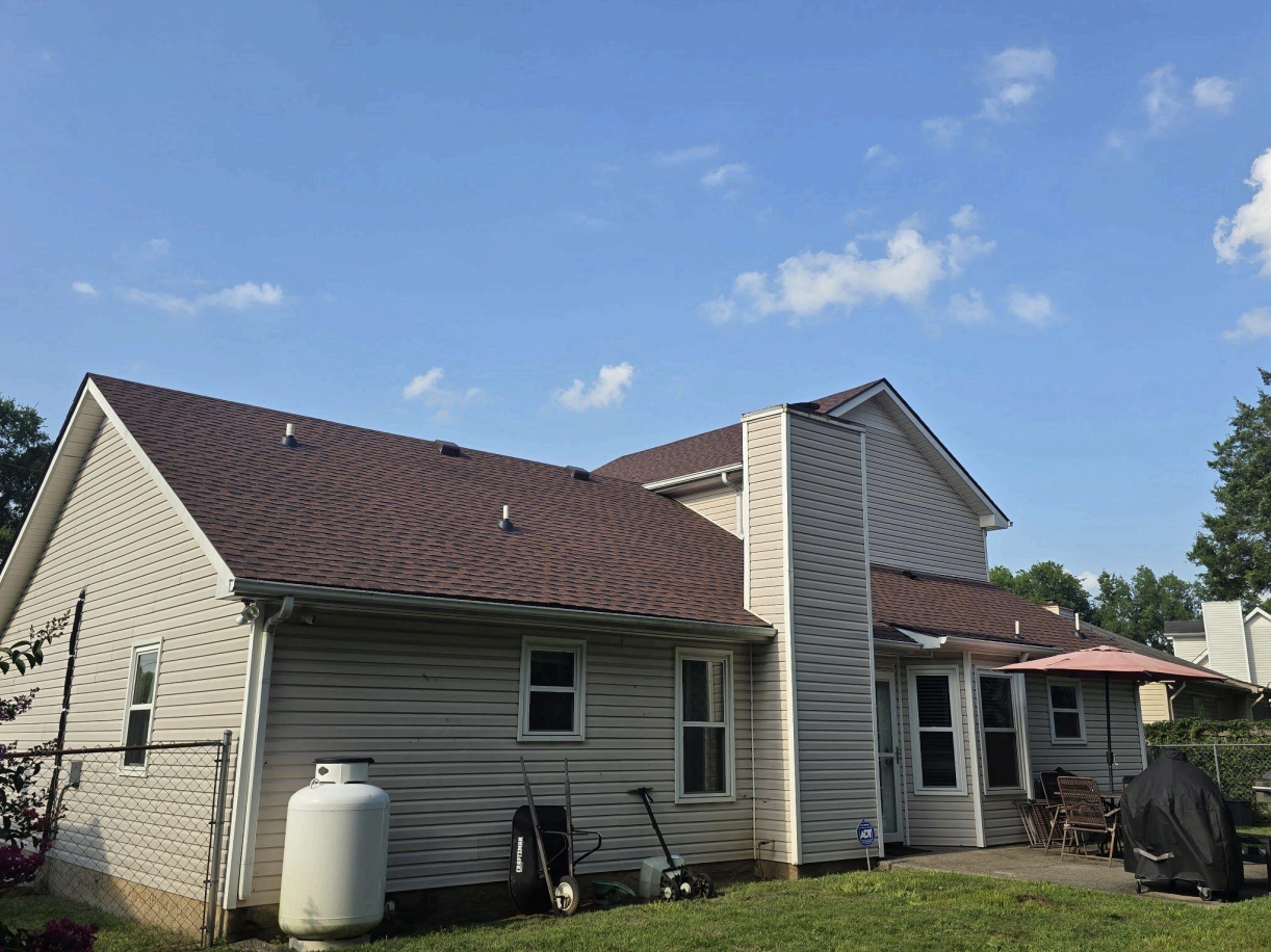 Beige siding residential home with completed dark gray asphalt shingle roof replacement