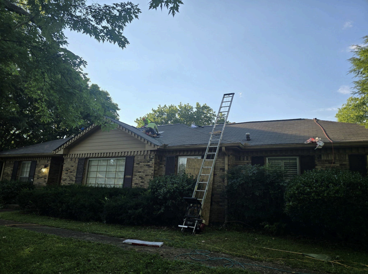 Brick ranch home with roof replacement in progress showing new shingles being installed