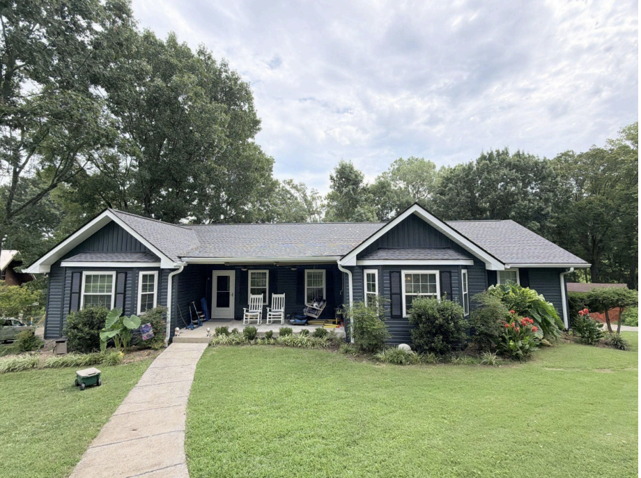 Residential home with completed navy blue asphalt shingle roof installation