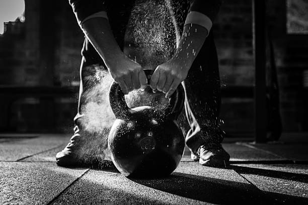 Athlete lifting a kettlebell in a gym, demonstrating strength training for runners