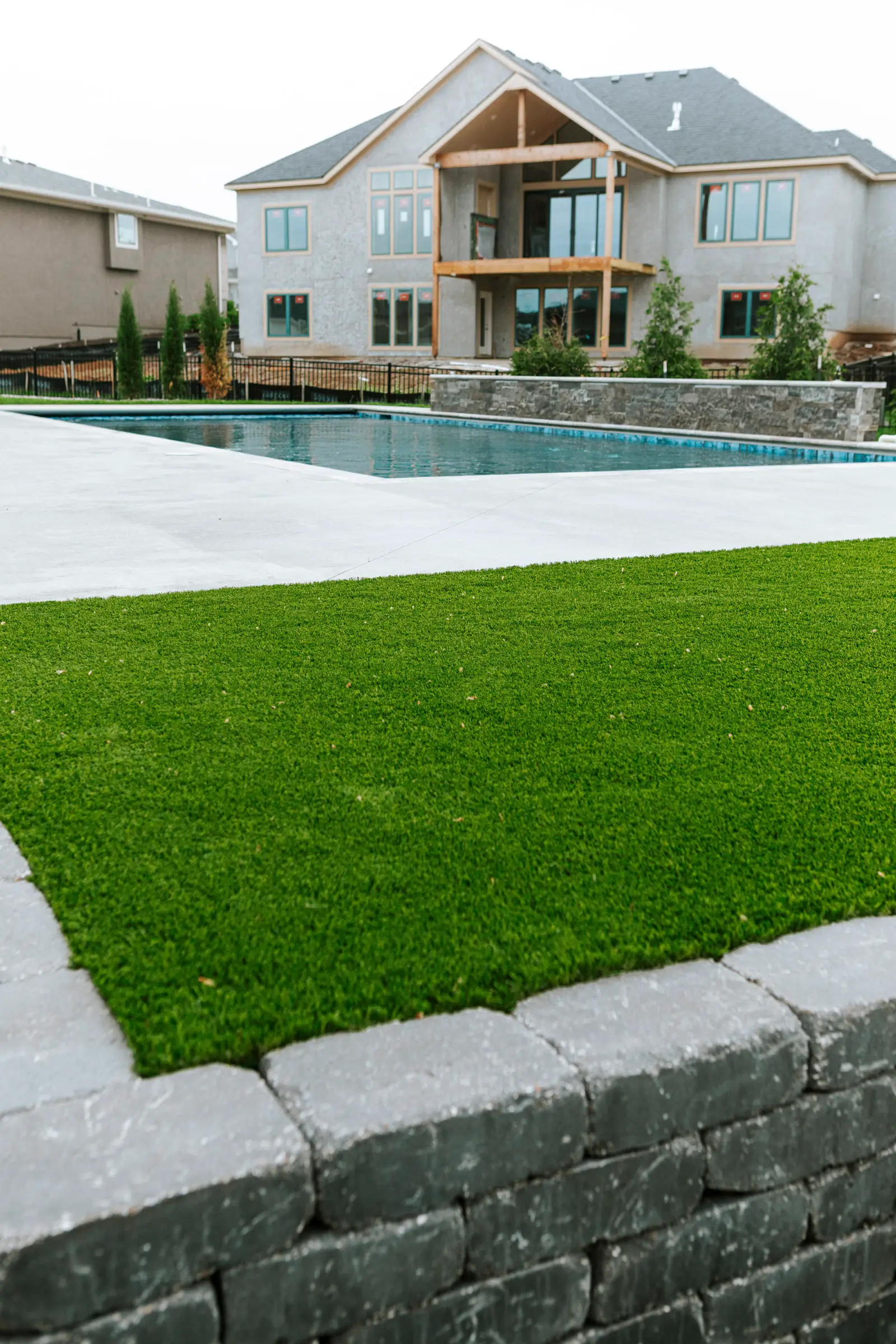 Poolside frustration showing muddy patchy grass beside concrete pool deck