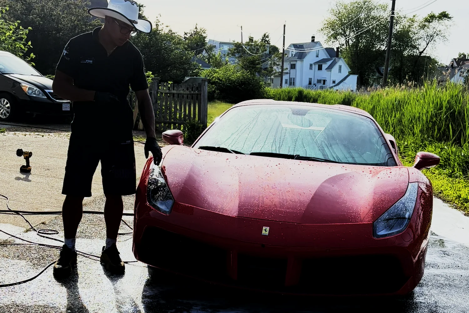 Isaiah applying The Obsidian Protocol ceramic coating to a red Ferrari in West Bridgewater MA