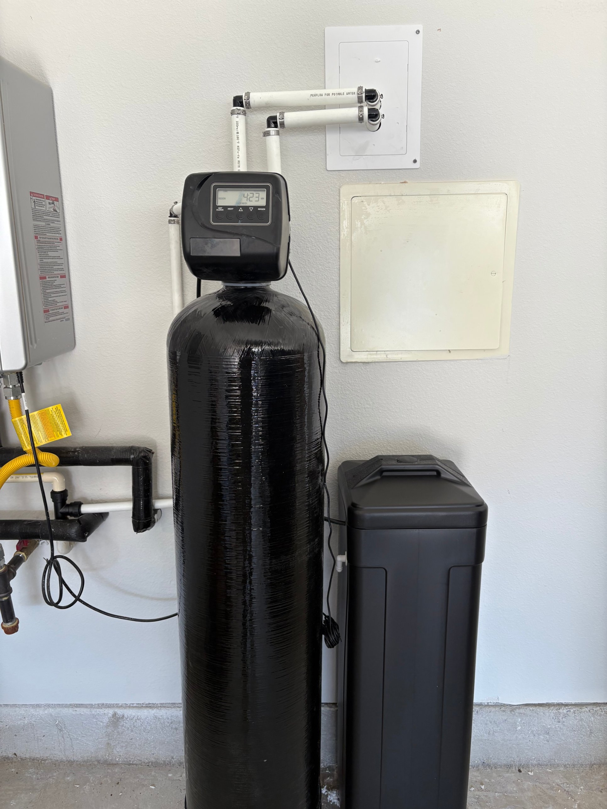 Brookwell whole-home water softener and brine tank installed in clean residential garage