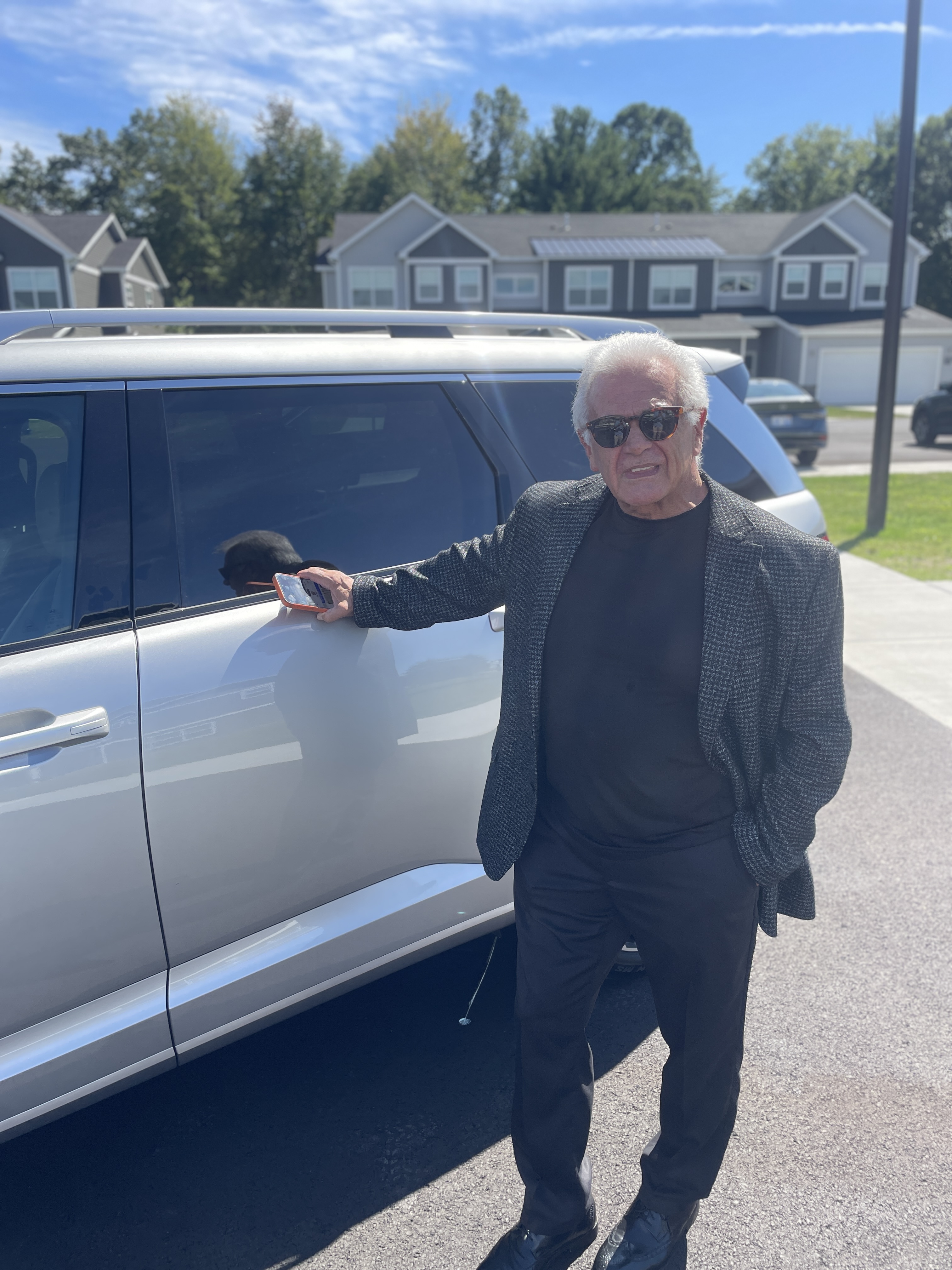 Michael Hanners standing alongside his spacious silver SUV