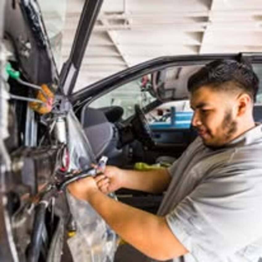 Technician performing electrical system work on vehicle at Center Cities Automotive