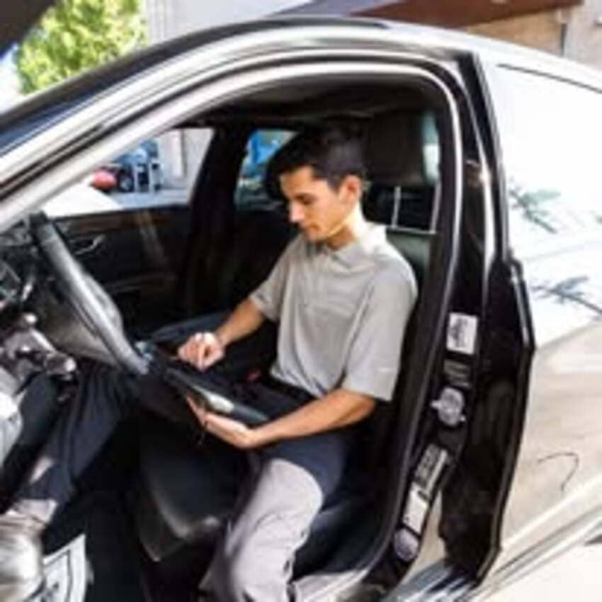 Technician working on vehicle interior at Center Cities Automotive