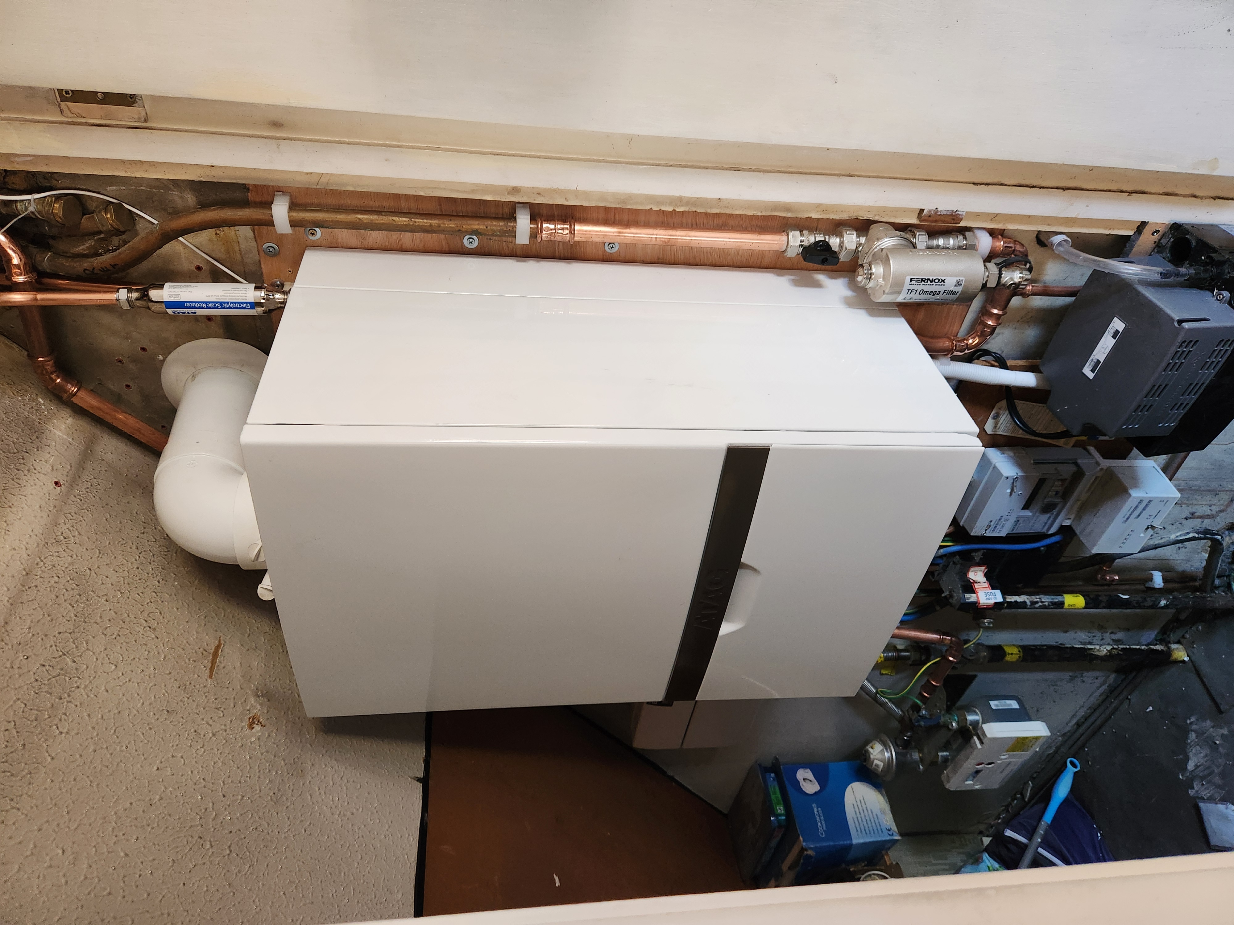 White Vaillant boiler neatly installed within a kitchen cupboard unit with magnetic filter, scale reducer and copper pipework.