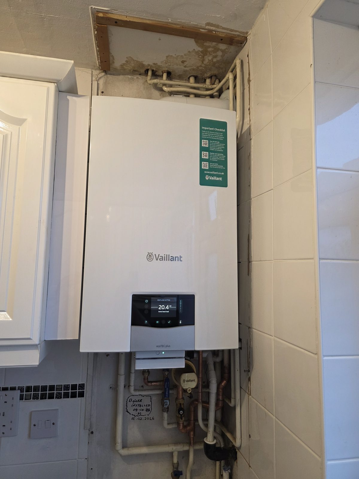 Wall-mounted Vaillant boiler installed with exposed pipework.