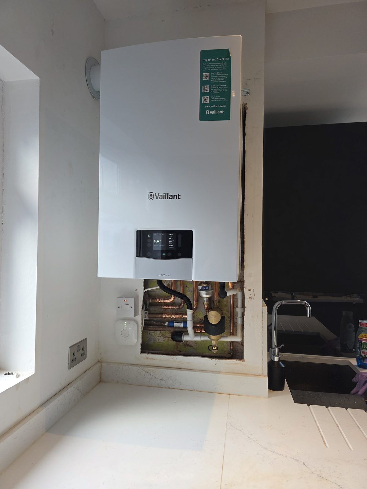Wall-mounted Vaillant ecoTEC plus boiler with exposed copper pipework and magnetic filter.